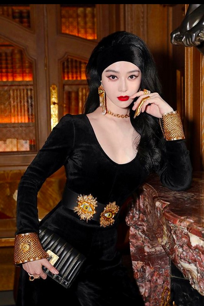 Tentu Fan Bingbing tampil head-to-toe dengan look keluaran Schiaparelli karya desainer Daniel Roseberry. Berbalut jumpsuit beludu serba hitam, ia melengkapi gayanya dengan aksesori emas dengan desain surealis khas Schiaparelli. (Foto: Instagram/@bingbing_fan)