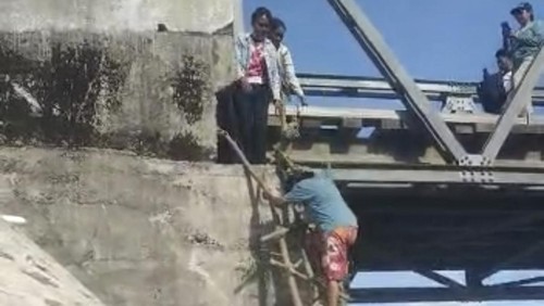 Video emak-emak nekat menyeberangi jembatan Termanu di Kupang, NTT, yang putus menggunakan tangga kayu darurat viral.