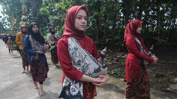 Sejumlah warga membawa kendi air saat Kirab Tradisi Merti Desa Godean di Godean, Pelem, Simo, Boyolali, Jawa Tengah, Minggu (5/3/2023).