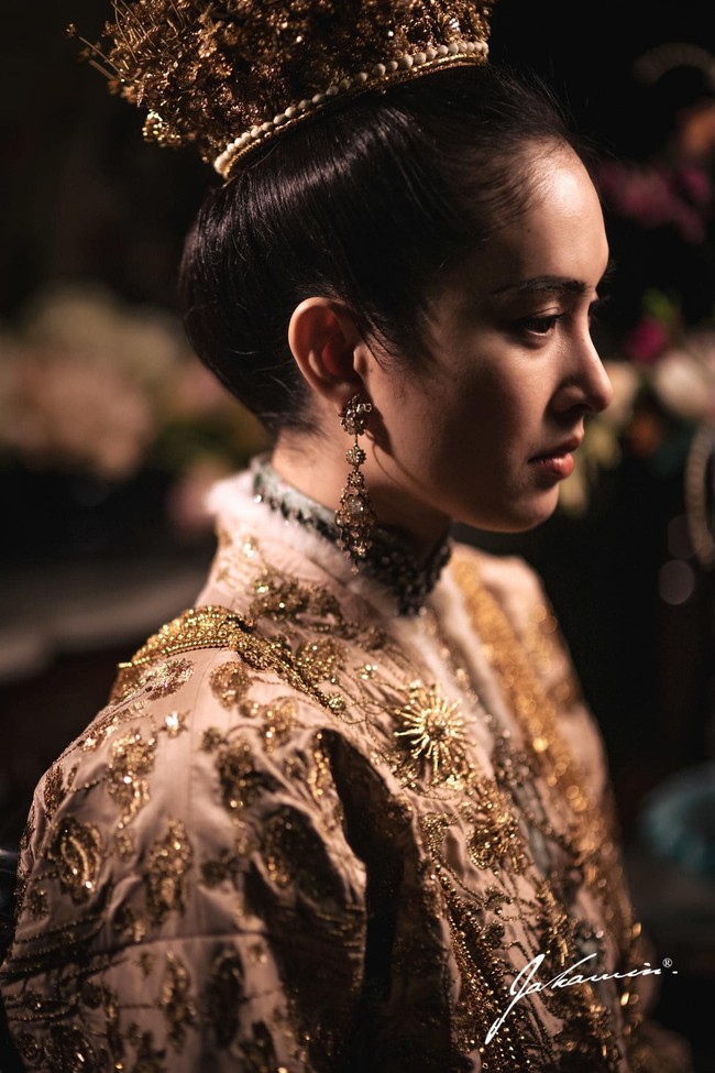Busana berwarna emas yang dikenakan Nong Poy seluruhnya dibuat dengan tangan alias tanpa mesin. Adalah brand bernama Meshmuseum yang berada di balik busana pengantin Nong Poy. “@poydtreechada in custom Meshmuseum Peranakan Attire featuring floral jacquard high collar shirt, vintage fur trim detailing and antique gold wire embroideries on a powder pink Thai silk base,” tulis brand tersebut dalam unggahannya. Foto: Dok. Instagram @chartmakeup, @achirakul
