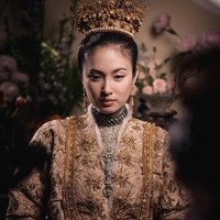 Baju pengantin Nong Poy yang berupa jubah ini dibuat dari sutra Prancis yang dipotong dengan kerah tinggi dan lengan lipit. Gaun ini juga berhiaskan bulu kelinci yang disulam motif poppy emas. Menurut adat peranakan, ini merupakan simbol dari ingatan, harapan dan kedamaian untuk masa depan. Foto: Dok. Instagram @chartmakeup, @achirakul