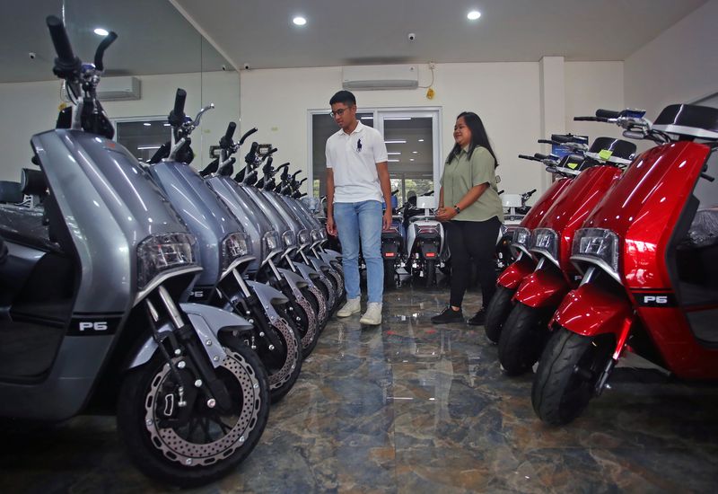 Calon pembeli didampingi tenaga penjual melihat motor listrik yang di jual di showroom motor listrik  Tangkas Ciater, Tangerang Selatan, Banten, Senin (6/3/2023). Pemerintah mulai 20 Maret 2023 memberikan subsidi kendaraan listrik, demi meningkatkan keterjangkauan harga dan daya beli masyarakat terhadap kendaraan listrik, serta memacu perkembangan industri otomotif energi baru. ANTARA FOTO/Muhammad Iqbal/hp.