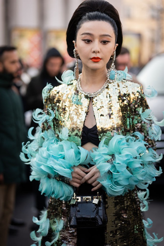 Fan Bingbing melengkapi gaya ultra glamornya dengan tas kulit mungil dan anting statement dengan batu tosca yang senada dengan busananya.  (Foto: Claudio Lavenia/Getty Images)