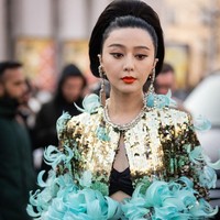 Fan Bingbing melengkapi gaya ultra glamornya dengan tas kulit mungil dan anting statement dengan batu tosca yang senada dengan busananya.  (Foto: Claudio Lavenia/Getty Images)