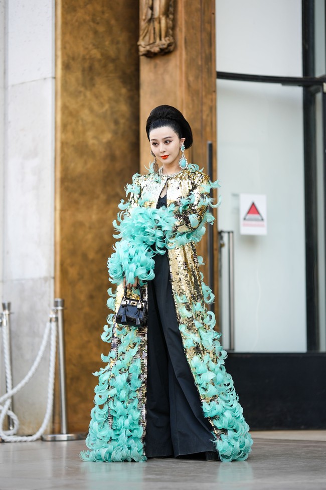 Keesokan harinya, ia muncul di peragaan busana siap pakai wanita Giambattista Valli. Kali ini, gayanya tak kalah glamor dengan gaun hitam yang dibungkus luaran penuh payet berwarna tembaga nan berkilauan dan berhiaskan detail bulu tosca. (Foto: Getty Images/Edward Berthelot)