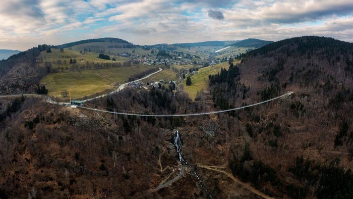 TOPSHOT - A panorama of 27 pictures taken on March 3, 2023 shows a suspended footbridge under construction, overlooking a waterfall in Todtnau, southwestern Germany. - The construction of the 450 meters long bridge suspended at a height of up to 120 meters is expected to be completed in May 2023 and to become a major tourist attraction in the Black Forest. (Photo by PATRICK HERTZOG / AFP) (Photo by PATRICK HERTZOG/AFP via Getty Images)