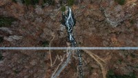 Jembatan yang dibangun menghadap air terjun ini diharapkan selesai pada Mei 2023.  