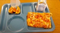 Sepotong pizza dan tiga potong jeruk dengan sekotak susu ini apakah cukup mengenyangkan? Salah satu murid mengadukan menu makan siang yang minim di sekolahnya. Foto: The New York Post