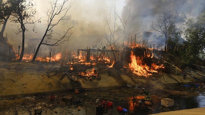 Rohingya refugees try to salvage their belongings after a major fire in their Balukhali camp at Ukhiya in Cox's Bazar district, Bangladesh, Sunday, March 5, 2023. A massive fire raced through a crammed camp of Rohingya refugees in southern Bangladesh on Sunday, leaving thousands homeless, a fire official and the United Nations said. (AP Photo/Mahmud Hossain Opu)
