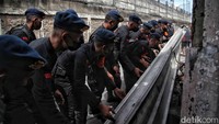 Para petugas bahu-membahu memperbaiki kerusakan.