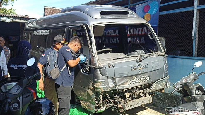 Tim Bidlabfor Polda Jatim memeriksa mobil rombongan GP Ansor Tulungagung yang diserang di Trenggalek hingga masuk parit.