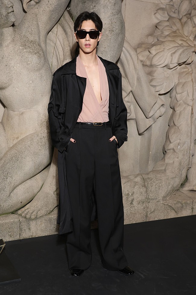 Satu lagi artis Korea yang menjadi tamu spesial Saint Laurent. Mark Tuan GOT7 hadir memakai atasan v-neck dibalut setelan trench coat Penampilannya dilengkapi dengan kacamata hitam. Foto: WWD via Getty Images/Swan Gallet