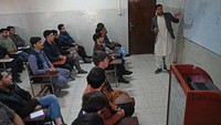 Mahasiswa menghadiri kelas ilmu komputer mereka setelah universitas dibuka kembali di Kabul. Pemerintah Afghanistan di bawah Taliban memberlakukan larangan tersebut setelah menuduh para mahasiswi mengabaikan aturan berpakaian dan persyaratan lain, termasuk kewajiban ditemani kerabat laki-laki dari dan menuju kampus. Wakil Kohsar/AFP/Getty Images