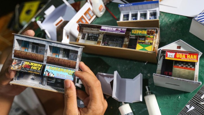 Perajin menyelesaikan pembuatan miniatur pertokoan di rumah produksi Craftoys 181, Depok, Jawa Barat, Selasa (7/3/2023). Kerajinan miniatur pertokoan dari bahan kertas art karton, pvc dan hardboad yang dipasarkan secara daring tersebut dijual seharga Rp 5.000 hingga Rp 250.000 per unit tergantung ukuran serta desain. ANTARA FOTO/Asprilla Dwi Adha/YU