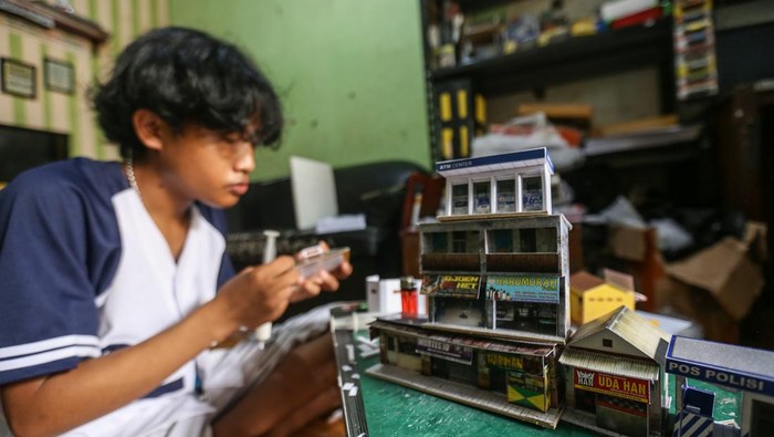Perajin menyelesaikan pembuatan miniatur pertokoan di rumah produksi Craftoys 181, Depok, Jawa Barat, Selasa (7/3/2023). Kerajinan miniatur pertokoan dari bahan kertas art karton, pvc dan hardboad yang dipasarkan secara daring tersebut dijual seharga Rp 5.000 hingga Rp 250.000 per unit tergantung ukuran serta desain. ANTARA FOTO/Asprilla Dwi Adha/YU