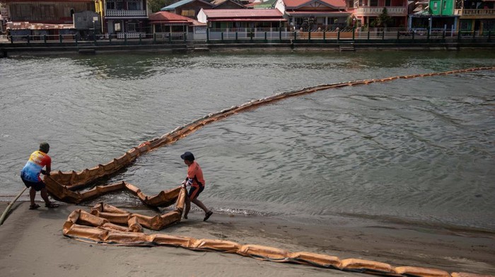 Coast guard personnel set up a floating boom to contain the oil spill from the sunken fuel tanker MT Princess Empress in the coastal town of Pola, Oriental Mindoro province, Philippines, March 6, 2023. REUTERS/Eloisa Lopez