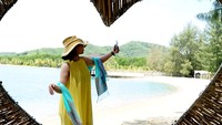 Pengunjung berswafoto di pantai objek wisata Villa Kencana di Botumoito, Kabupaten Boalemo, Gorontalo, Selasa (7/3/2023).  
