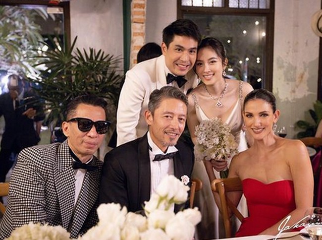 Penampilan Nong Poy dan Oak yang juga serasi dengan mengenakan jas putih. Mereka menyambut tamu mereka yang datang dari kalangan pejabat dan artis. Foto: dok. Instagram/@poydtreechada