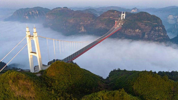 Jembatan gantung Aizhai yang berada di Jishou, China ini memiliki pemandangan yang dapat memanjakan mata. Pengendara yang melintas serasa berada di atas awan.