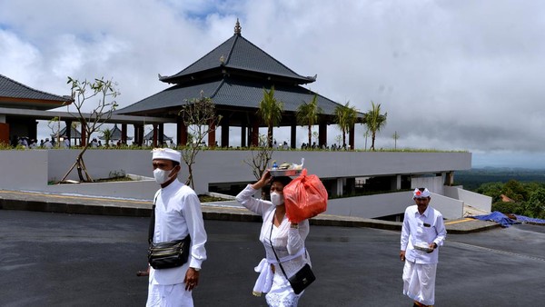 Umat Hindu berjalan di dekat gedung parkir baru yang dibangun dalam proyek revitalisasi dan pengembangan Kawasan Suci Pura Agung Besakih di Karangasem, Bali, Senin (6/3/2023).
