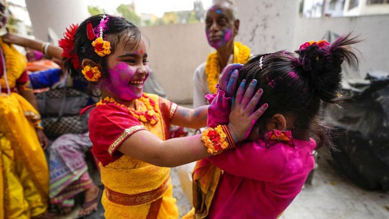 Hindu devotees smeared in color take out an idol of deity Krishna on a car during Holi festival in Kolkata, India, Sunday, March 5, 2023. (AP Photo/Bikas Das)