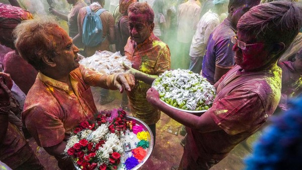Dalam festival ini, warga saling melempar serbuk warna-warni. AP/Bikas Das  