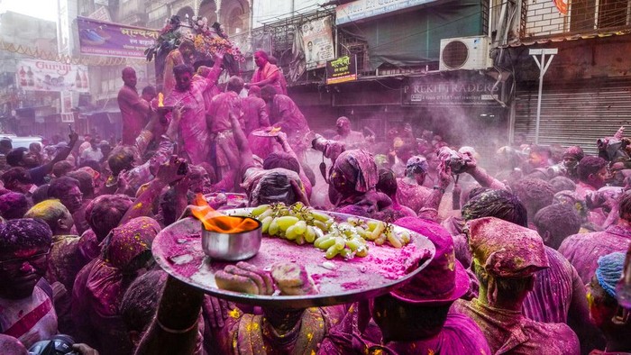 Potret Kemeriahan Festival Holi di India Hindu devotees smeared in color take out an idol of deity Krishna on a car during Holi festival in Kolkata, India, Sunday, March 5, 2023. (AP Photo/Bikas Das)