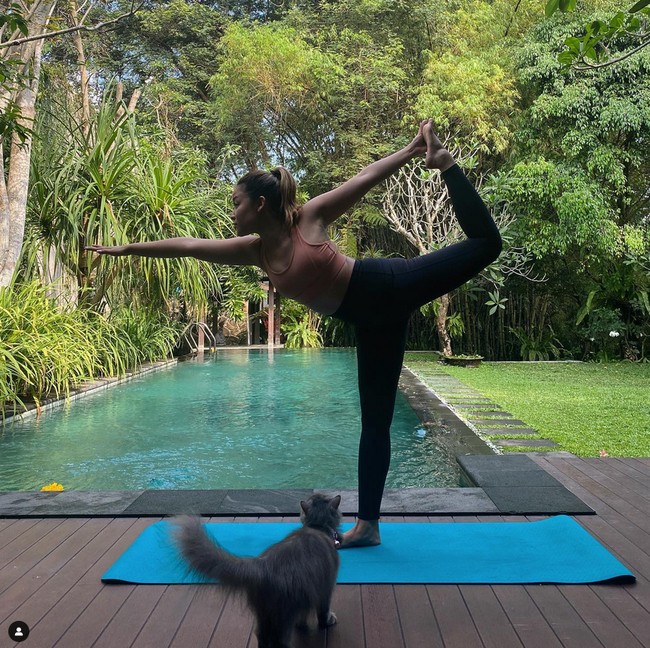 Sang kakak, Kirana Karang yang menetap di Yogyakarta kerap membagikan foto rumah keluarganya di Instagram. Seperti saat yoga di dekat kolam renang ditemani anabul. Foto: Instagram