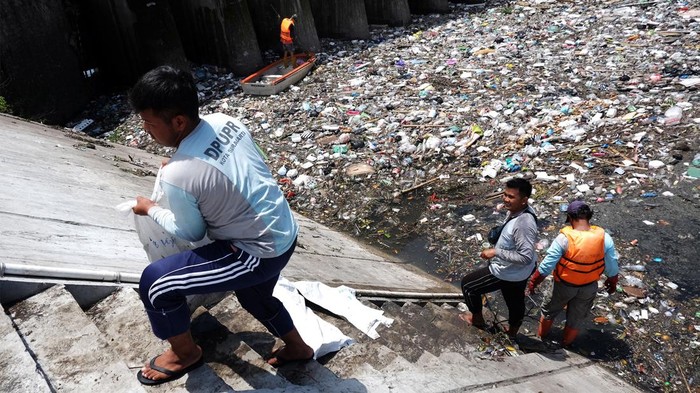 Sejumlah petugas membersihkan sampah rumah tangga yang menumpuk di pintu air Demangan Lama, Solo, Jawa Tengah, Selasa (7/3/2023). Selain untuk menjaga kebersihan dan kelancaraan laju air di Sungai Bengawan Solo, kegiatan tersebut juga sebagai edukasi agar masyarakat tidak buang sampah di sungai dan antisipasi terjadinya bencana banjir.ANTARA FOTO/Maulana Surya/YU