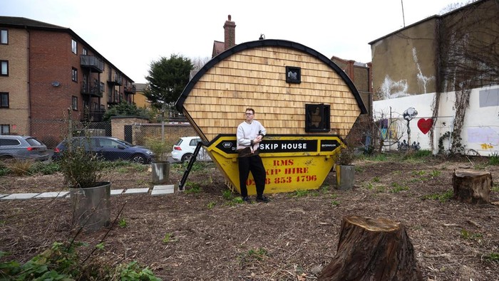Seniman Inggris Pindah ke 'Tempat Sampah' Soroti Krisis Biaya Hidup Artist Harrison Marshall poses inside the skip which he has converted into a home, where he intends to live in for a year, in Bermondsey, London, Britain, March 3, 2023. REUTERS/Henry Nicholls