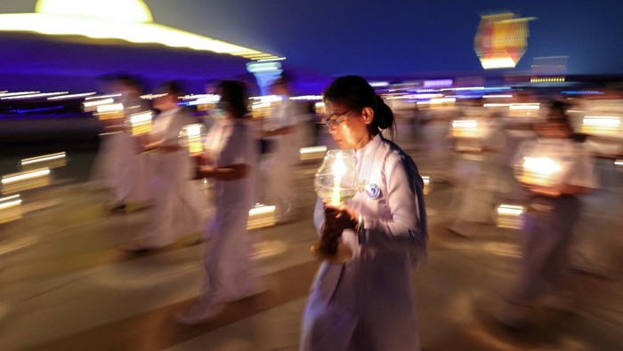 Buddhist monks carry candle lights at the Wat Phra Dhammakaya temple during a ceremony commemorating Makha Bucha Day in Pathum Thani province outside Bangkok, Thailand, March 6, 2023. REUTERS/Athit Perawongmetha