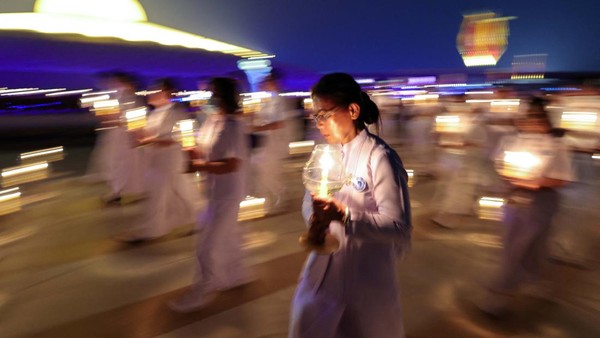 Umat Buddha di Thailand menyalakan lilin dan lentera untuk memperingati Hari Makha Bucha, Senin (6/3/2023). 