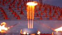 Ribuan orang berbaju putih dan biksu berjubah kuning kunyit berjalan di sekitar stupa suci Kuil Dhammakaya dekat Bangkok, memegang lilin dan melantunkan doa dalam bahasa Pali, bahasa kitab suci Buddha.