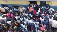 Penumpang berbondong-bondong naik kereta menuju kota asal mereka di Stasiun Patna, India, Minggu (6/3/2023) waktu setempat.  