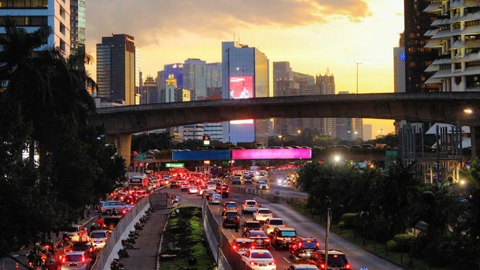 Downtown Jakarta busy city scene at sunset with heavy traffic un the highway under the overpasses.