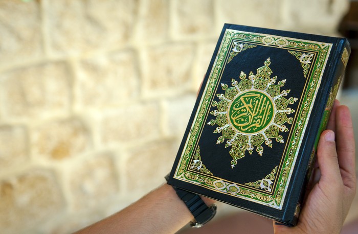 A young man holding the Quran at a mosque in Lebanon