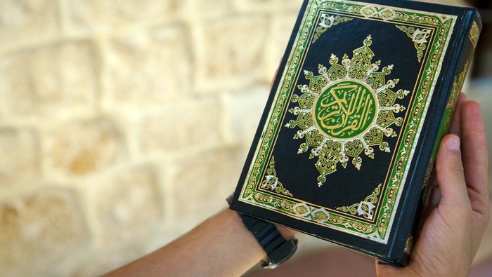 A young man holding the Quran at a mosque in Lebanon