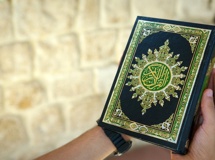 A young man holding the Quran at a mosque in Lebanon