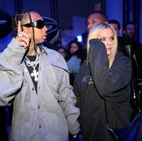 Tampak Tyga mengenakan kemeja dan celana kebesaran warna abu-abu dengan kalung-kalung silver besar. Foto: dok. Getty Images/Stephane Cardinale - Corbis