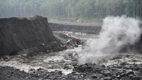 Penambang pasir mengamati aliran lahar hujan. Selain warga, aktivitas penambang pasir di wilayah tersebut juga terhentikan.
