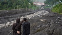 Warga melihat aliran material lahar hujan Gunung Semeru di Kamar Kajang, Desa Sumberwuluh, Candipuro, Lumajang, Jawa Timur, Rabu (8/3/2023).