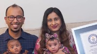 Dalam situs resmi Guinness World Records, sebuah foto memperlihatkan si kembar duduk di sofa. Adiah tampak terkejut dengan mulut yang terbuka lebar, sementara sang kakak Adrial tampak termenung. (Foto: Guinness World Records).