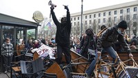 Para pengunjuk rasa berdiri di barikade selama demonstrasi di Lyon. Serikat pekerja telah berjanji untuk membuat negara terhenti dengan pemogokan atas perubahan yang diusulkan. AP/Laurent Cipriani