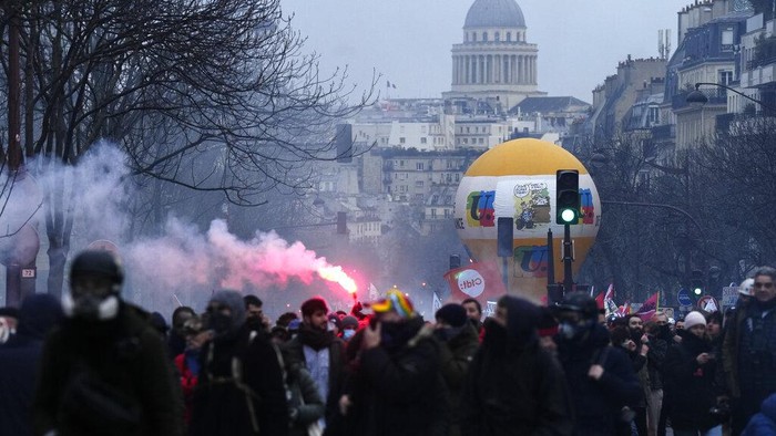 Protesters march, with the Pantheon monument in background, during a demonstration, Tuesday, March 7, 2023 in Paris. Demonstrators were marching across France on Tuesday in a new round of protests and strikes against the governments plan to raise the retirement age to 64, in what unions hope to be their biggest show of force against the proposal. (AP Photo/Lewis Joly)