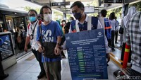 Beberapa petugas TransJakarta tampak memberikan informasi kepada penumpang yang bertanya mengenai rute.