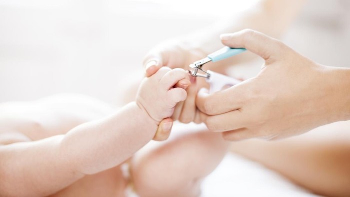 Mother cutting babys nails