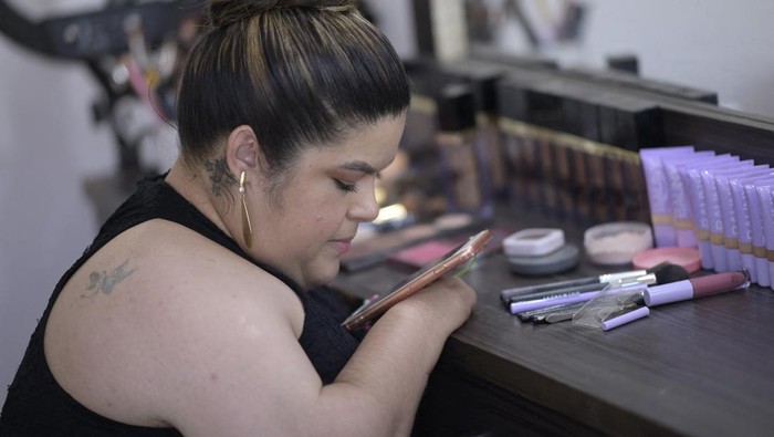 Brazilian make-up artist Clelia Rodriguez, who was born with arthrogryposis, applies make-up to a client in her salon in Visconde do Rio Branco, state of Minas Gerais, Brazil, on March 7, 2023. - Rodrigues was born with arthrogryposis, which limits her arm movements, but nevertheless the 29-year-old Brazilian managed to become a make-up artist and succeed on social media, posting her work and make-up tips. (Photo by DOUGLAS MAGNO / AFP) (Photo by DOUGLAS MAGNO/AFP via Getty Images)