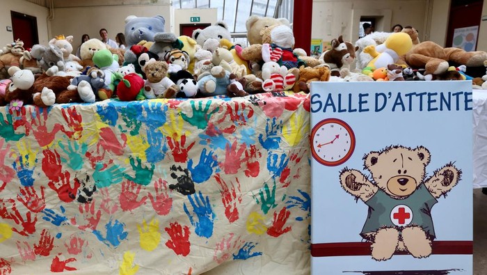 A student of medicine, acting as specialist staff, is accompanied by a child who came with a plush toy to be treated at The Teddy Bear Clinic (Clinique du Nounours), a facility that helps children to cope with their fear of medical examinations, in Brussels, Belgium March 7, 2023. REUTERS/Yves Herman     TPX IMAGES OF THE DAY
