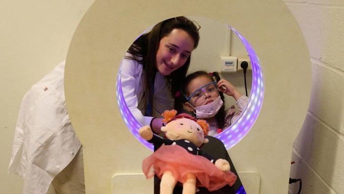 A student of medicine, acting as specialist staff, is accompanied by a child who came with a plush toy to be treated at The Teddy Bear Clinic (Clinique du Nounours), a facility that helps children to cope with their fear of medical examinations, in Brussels, Belgium March 7, 2023. REUTERS/Yves Herman     TPX IMAGES OF THE DAY