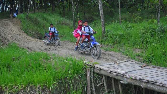 Potret Mirisnya Jalan Rusak di Grobogan Pelajar mengendarai sepeda motor melintasi jalan tanah di kawasan hutan Dusun Kalitengah, Rejosari, Kradenan, Grobogan, Jawa Tengah, Selasa (7/3/2023). Menurut warga setempat, sejak puluhan tahun yang lalu akses jalan utama sepanjang tiga kilometer menuju Dusun Kalitengah yang terdapat kurang lebih 300 KK itu belum tersentuh pembangunan infrastruktur jalan, dan saat musim hujan kondisinya berlumpur. ANTARA FOTO/Yusuf Nugroho/tom.